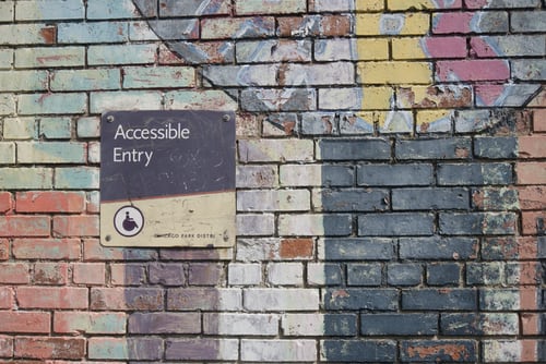 brick wall with a sign saying Accessible Only