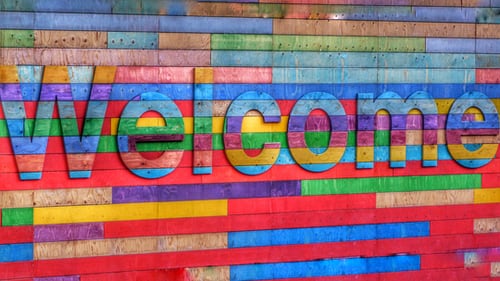 Mulit-coloured brick wall with the words Welcome