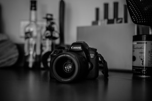 Canon camera on desk photographed in greyscale