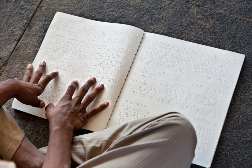 Child's hands reading braille